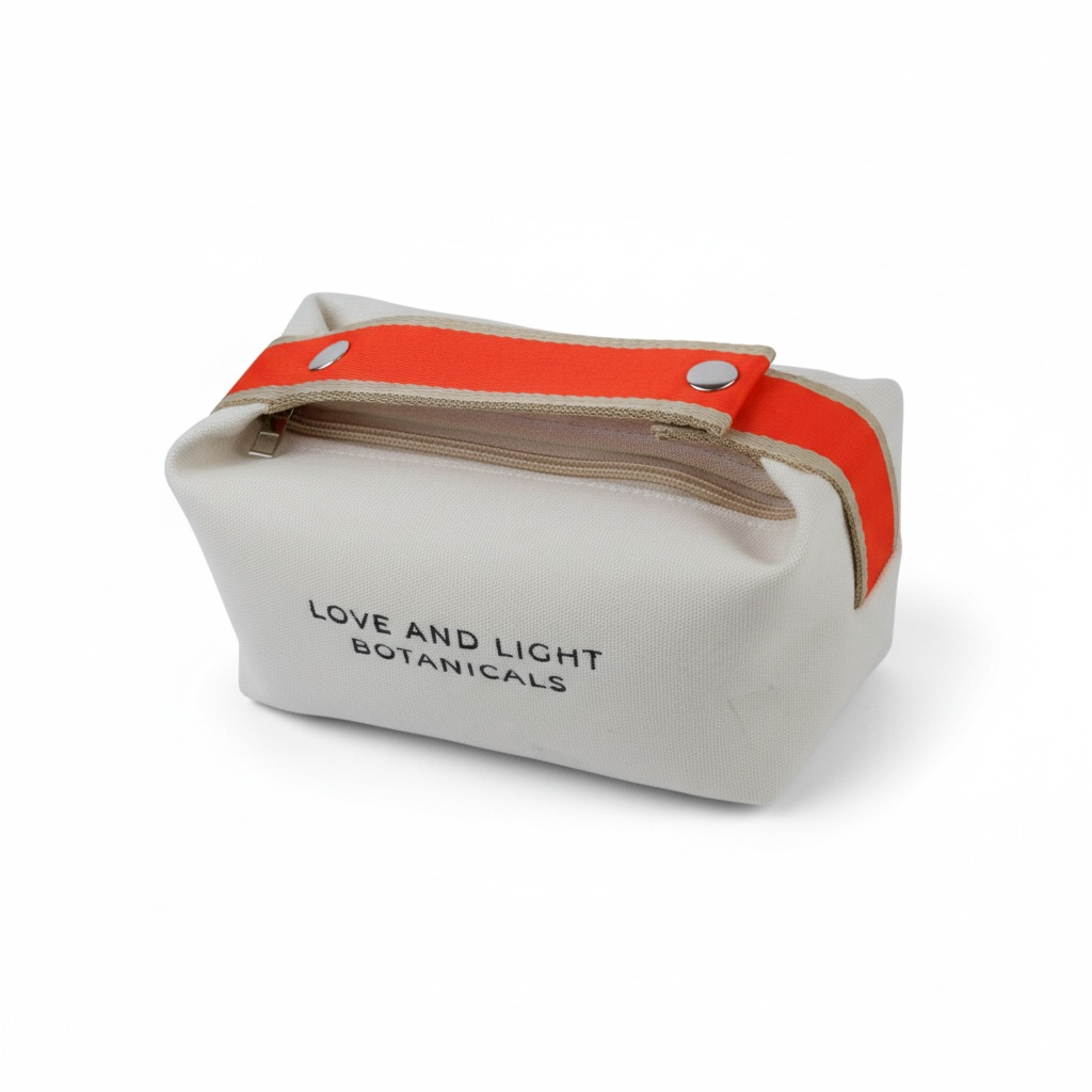 White hemp-jute cosmetic case with tangerine handle + metal snaps, angled side view