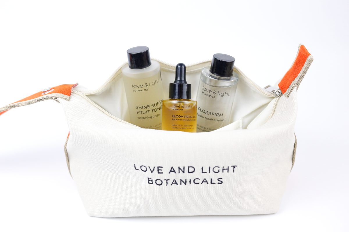 Open white hemp-jute cosmetic case holding Shine superfruit tonic, Bloom facial oil + Florafirm barrier repair essence